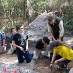 UoB graduate student, Henry Webber, teaching the CHSS students the process of troweling a trench. 2014