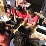 CHSS students cleaning artifacts in the sun. 2014