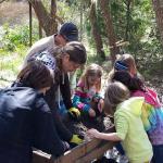 UoB student, Ryan Neal teaching the young minds the basics of archaeology sifting... and some 'football' soccer tips on the side!